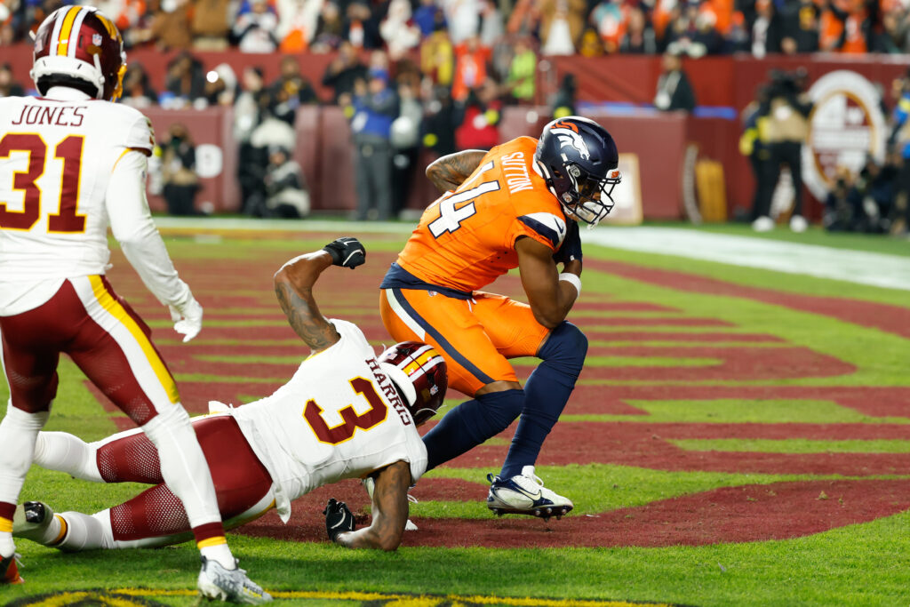 Nov 30, 2025; Landover, Maryland, USA; Denver Broncos wide receiver Courtland Sutton (14) scores a touchdown defended by Washington Commanders safety Will Harris (3) in the second quarter of the game at Northwest Stadium. Mandatory Credit: Geoff Burke-Imagn Images